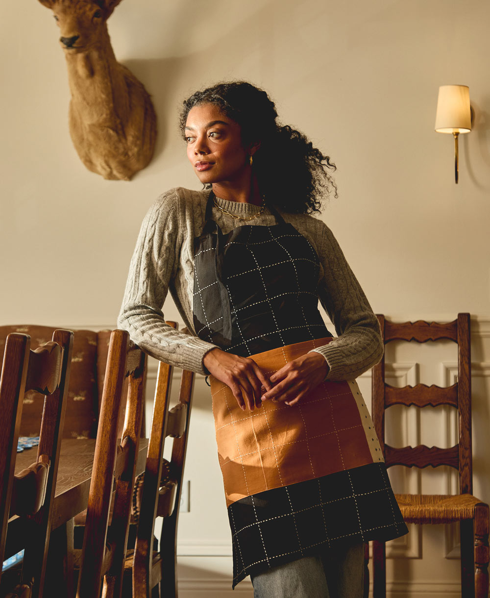 Mujer con el mandil Charcoal en una cocina