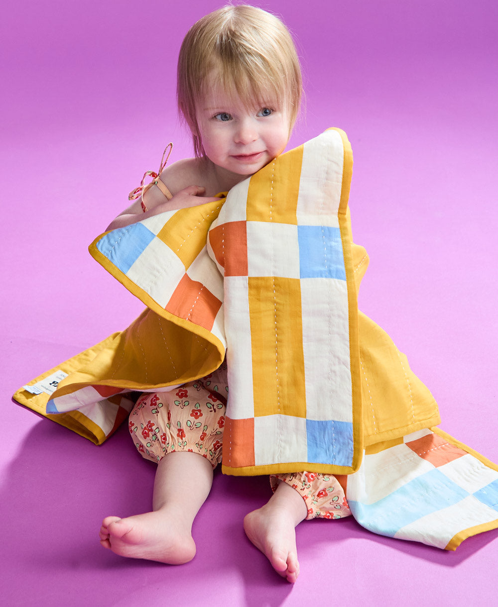 Bebé envuelta en el Tile Baby Quilt
